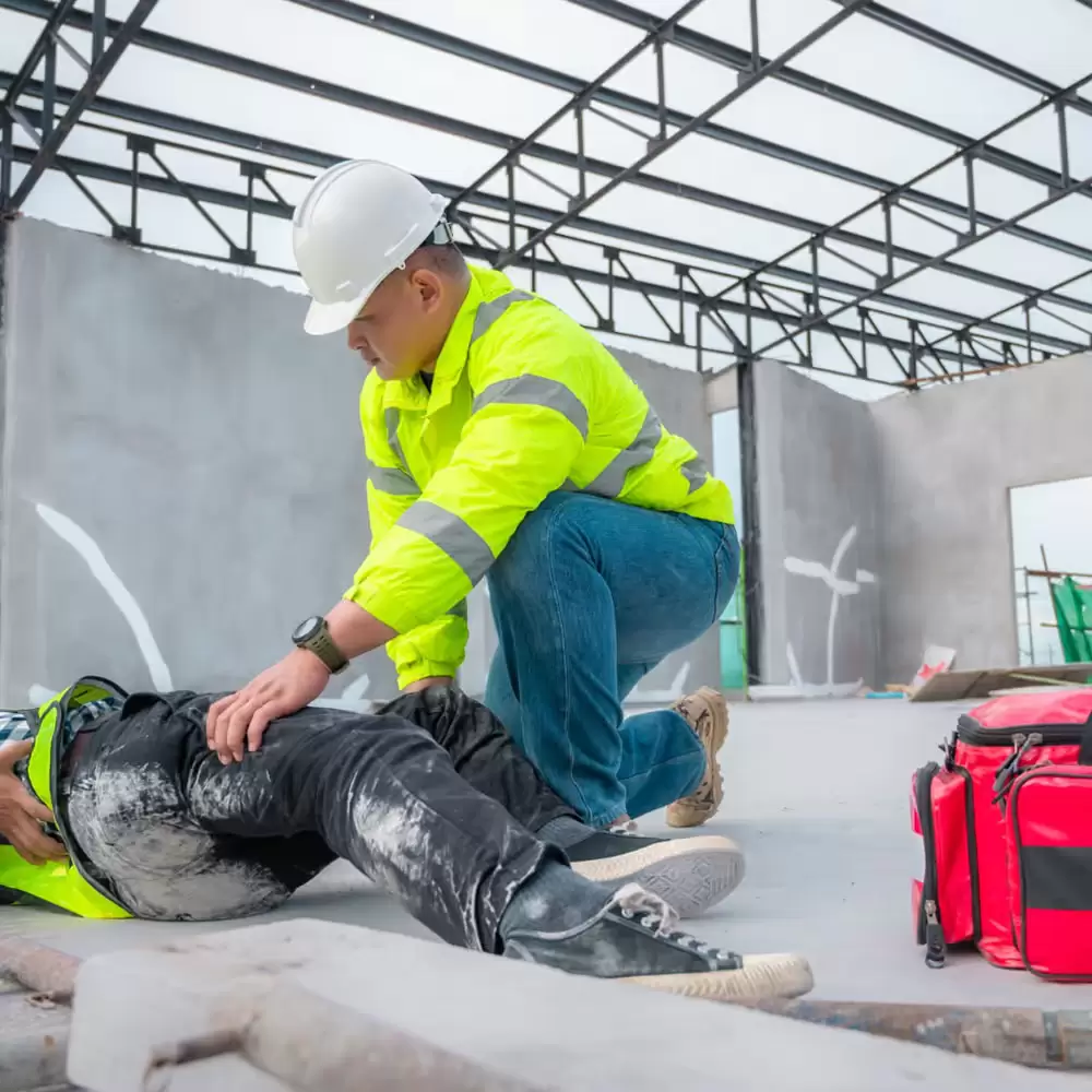 A worker placing a colleague in the recovery position.